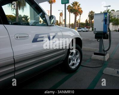 19 dicembre 2004; Venice Beach, CA, USA; auto elettrica Toyota RAV 4 SUV in una stazione di ricarica pubblica. Un veicolo elettrico è un veicolo azionato da motori elettrici. Il problema principale dei veicoli elettrici a batteria è la loro autonomia limitata rispetto ai veicoli a benzina e il numero limitato di cicli di carica forniti prima della sostituzione della batteria. Il problema dell'autonomia potrebbe essere affrontato mediante l'uso di veicoli ibridi a gas-elettrici che utilizzano un motore elettrico e batterie ricaricabili a rete per l'accelerazione e la guida a bassa velocità, con il Foto Stock