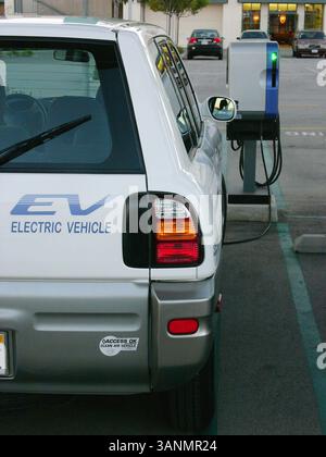 19 dicembre 2004; Venice Beach, CA, USA; auto elettrica Toyota RAV 4 SUV in una stazione di ricarica pubblica. Un veicolo elettrico è un veicolo azionato da motori elettrici. Il problema principale dei veicoli elettrici a batteria è la loro autonomia limitata rispetto ai veicoli a benzina e il numero limitato di cicli di carica forniti prima della sostituzione della batteria. Il problema dell'autonomia potrebbe essere affrontato mediante l'uso di veicoli ibridi a gas-elettrici che utilizzano un motore elettrico e batterie ricaricabili a rete per l'accelerazione e la guida a bassa velocità, con il Foto Stock