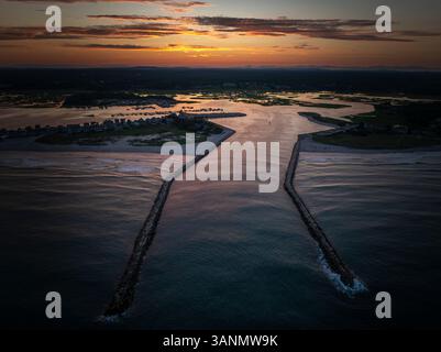 Vista aerea del tranquillo tramonto sull'oceano calmo e sulla pittoresca spiaggia con molo e molo, Wells, Stati Uniti. Foto Stock