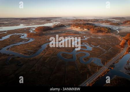 Vista aerea della tranquilla palude, del tortuoso fiume e della strada tortuosa in autunno, Ipswich, Massachusetts, Stati Uniti. Foto Stock