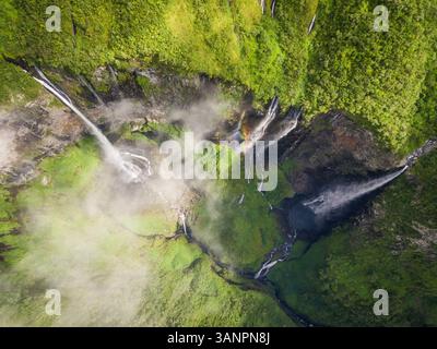 Vista aerea sopra la cascata circondata dalla giungla, Faroe Island. Foto Stock
