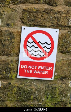 Un cartello di avvertimento che dice "non entrare in acqua", Inghilterra, Regno Unito Foto Stock