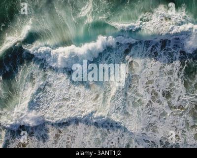 Veduta aerea di un'enorme onda in mezzo all'oceano Atlantico in Portogallo. Vista mozzafiato su un oceano turchese tempestoso Foto Stock
