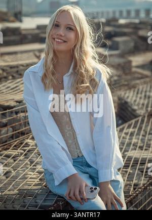 ritratto di una giovane donna, sorridente, che guarda la macchina fotografica Foto Stock