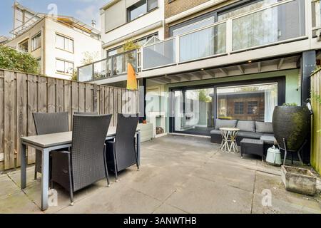 Spazioso patio esterno con mobili eleganti e un ambiente sereno, perfetto per rilassarsi o intrattenere gli ospiti in un ambiente contemporaneo. Foto Stock