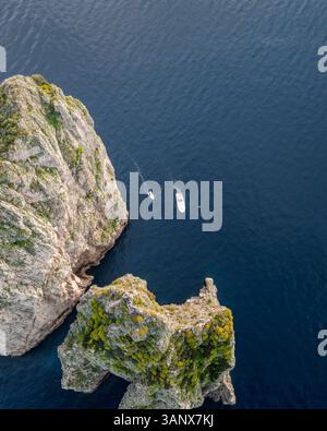 Vista aerea della costa frastagliata con scogliere ripide e barche all'isola di Capri, Napoli, Italia. Foto Stock