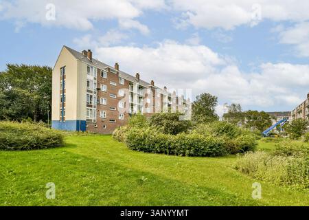 Un complesso residenziale contemporaneo immerso nel verde lussureggiante, che mostra la vita urbana in armonia con la natura, ideale per la comunità e la vita familiare. Foto Stock