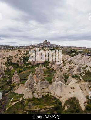 Vista aerea della valle di Goreme e del Parco Nazionale con la formazione di rocce di camino delle fate con il castello di Uchisar e la città sullo sfondo Cappadocia, Nevsehir, Turchia. Foto Stock