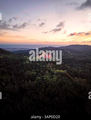 Vista aerea del Palazzo pena, un colorato castello romanticista in cima a una collina durante un bellissimo tramonto, Sintra, Lisbona, Portogallo. Foto Stock