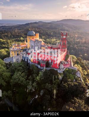 Vista aerea del Palazzo pena, un colorato castello romanticista in cima a una collina durante un bellissimo tramonto, Sintra, Lisbona, Portogallo. Foto Stock