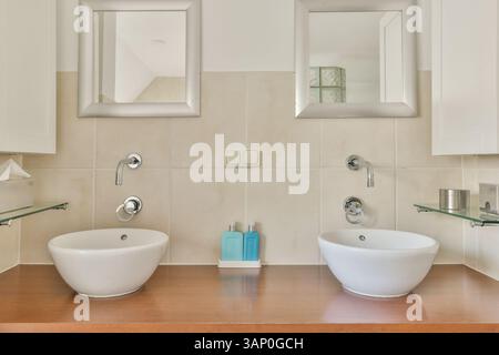 Bagno dal design elegante con due eleganti lavandini, arredamento minimalista e finiture contemporanee per un'estetica pulita. Foto Stock
