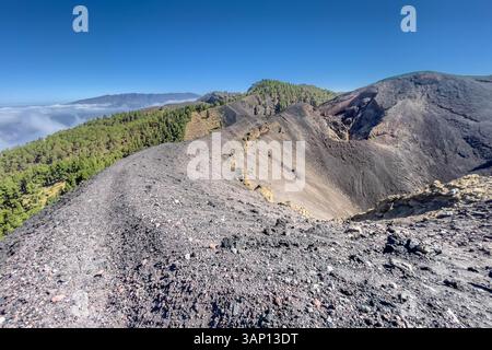 Trekking sul cratere nel paesaggio vulcanico lungo la Ruta de los Volcanes, splendido sentiero escursionistico sui vulcani dell'isola di la Palma, Isole Canarie, Spagna. Foto Stock