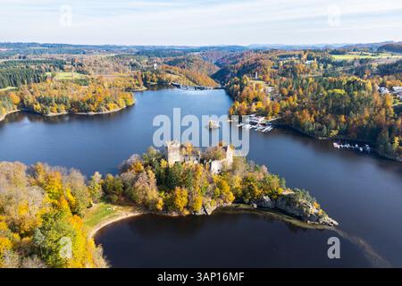 Vista aerea di una tranquilla scena autunnale caratterizzata da una storica rovina di un castello su una penisola accanto a un tranquillo lago circondato da lussureggianti foreste, Zwettl, Austria. Foto Stock