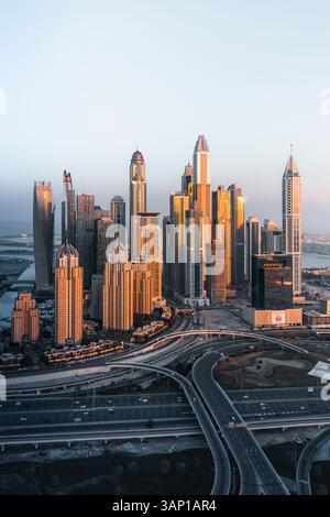 Dubai, Emirati Arabi Uniti - 14 febbraio 2022: Vista aerea dello skyline del porticciolo di dubai con moderni grattacieli e l'autostrada trafficata al tramonto, Dubai, United Foto Stock