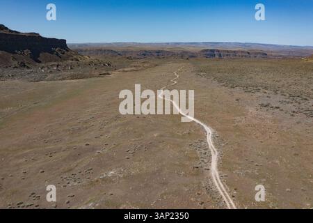 Vista aerea dell'aspro sentiero per mountain bike attraverso il vasto e arido paesaggio sotto un cielo limpido, Ancient Lakes, Grant County, Stati Uniti. Foto Stock