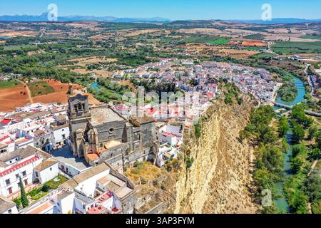 Vista aerea di Iglesia de San Pedro e delle case bianche sul bordo delle scogliere di Arcos de la Frontera, Andalusia, Spagna. Foto Stock