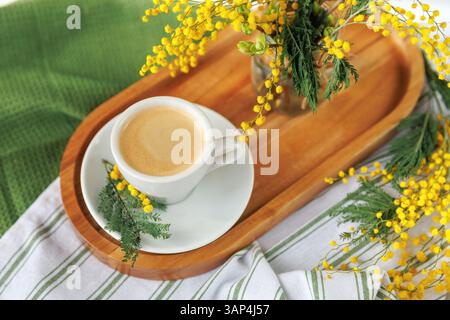 Caffè mattutino di primavera con fiori di mimosa su un vassoio di legno Foto Stock