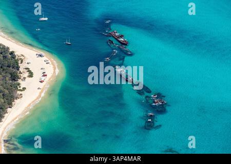 Vista aerea di relitti, spiaggia e barche a vela sull'oceano turchese, Moreton Island, Queensland, Australia. Foto Stock