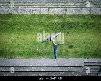 Vista aerea di una donna incinta che salta sopra l'uomo lungo il fiume Drava a Osijek, Osijek-Baranja, Croazia. Foto Stock
