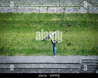 Vista aerea di una donna incinta che salta sopra l'uomo lungo il fiume Drava a Osijek, Osijek-Baranja, Croazia. Foto Stock