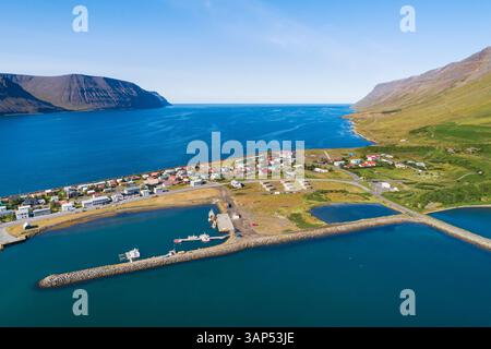 Vista aerea del villaggio Flateyri nel fiordo Onundarfjordur con montagne e mare, Westfjords, Islanda Foto Stock