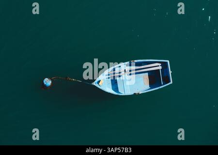Vista aerea di una piccola barca di legno blu che galleggia nel Mar Mediterraneo, Malta. Foto Stock