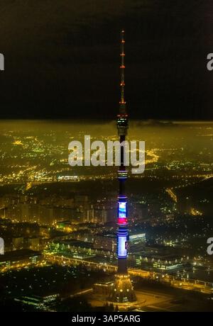 Veduta aerea della torre illuminata di ostankino in mezzo a un vivace paesaggio urbano di notte, Mosca, Russia. Foto Stock
