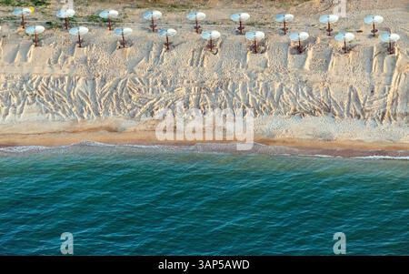 Vista aerea della splendida spiaggia sabbiosa con ombrelloni lungo la tranquilla costa, Temryuksky Bay, Russia. Foto Stock