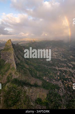 Vista aerea delle maestose montagne con un vivace arcobaleno e spettacolari nuvole su una lussureggiante valle, Tamarin, Riviere Noire, Mauritius. Foto Stock