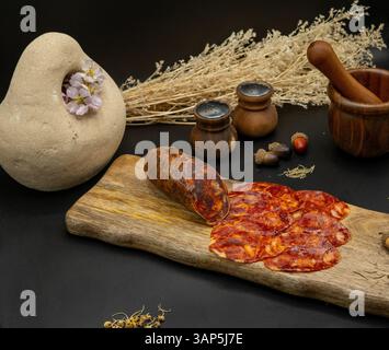 Uno squisito banco di salumi artigianali con fette di Chorizo servite su un banco di legno rustico Foto Stock
