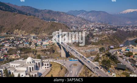 Vista aerea del ponte commemorativo del terremoto che attraversa un fiume con montagne sullo sfondo, Muzaffarabad, Azad Jammu Kashmir, Pakistan. Foto Stock