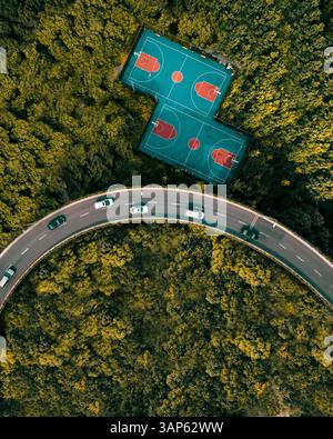 Vista aerea di due campi da tennis lungo l'autostrada che attraversa il bosco, Shanghai, Cina. Foto Stock