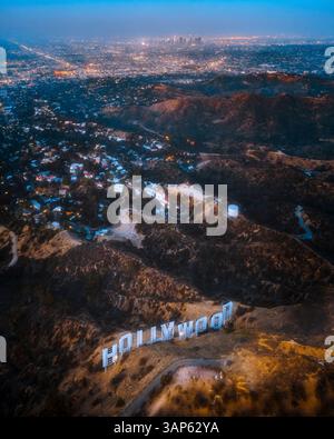 Los Angeles, Stati Uniti - 25 luglio 2018: Vista aerea dell'insegna di Hollywood sulla cima della collina al tramonto con lo skyline di Los Angeles sullo sfondo, California, Stati Uniti. Foto Stock