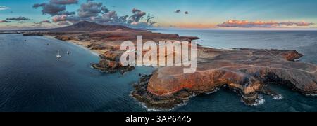 Vista aerea della spiaggia di papagayo all'ora d'oro durante il tramonto con una pittoresca costa e un oceano tranquillo, Costa de Papagayo, Lanzarote, Spagna. Foto Stock