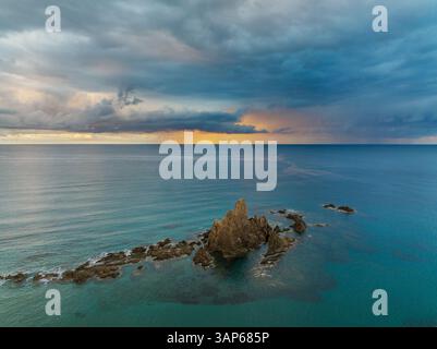 Vista aerea delle spettacolari formazioni rocciose e del tranquillo oceano al tramonto, Arrecife de las Sirenas, Cabo de Gata, Almeria, Spagna. Foto Stock