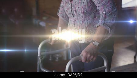 Immagine di una luce che si muove sulla sezione centrale di una donna anziana utilizzando un telaio da passeggio Foto Stock