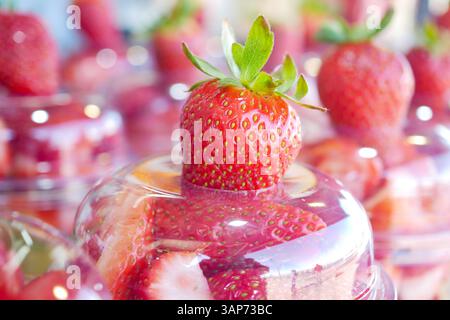 Fragole fresche esposte in bicchieri limpidi in un mercato estivo Foto Stock