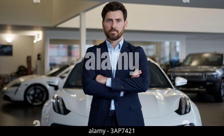 Uomo caucasico fiducioso incrociato Arms Manager venditore consulente consulente showroom specialista concessionaria auto uomo d'affari uomo uomo d'affari maschile Foto Stock