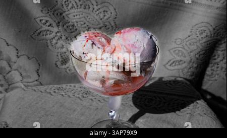 Una ciotola di gelato alle fragole. Il recipiente è pieno a metà e il gelato si sta sciogliendo Foto Stock