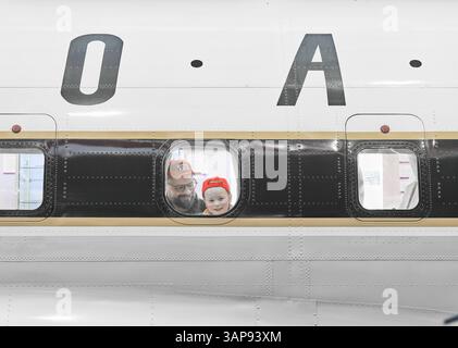 Padre e figlio guardano fuori dalla finestra al Concorde Aircraft al british Imperial War Museum, aeroporto di Duxford, Inghilterra. Foto Stock