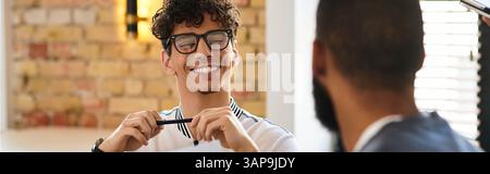 Due professionisti si godono un momento di luce in un ufficio elegante, stimolando il lavoro di squadra e la creatività. Foto Stock