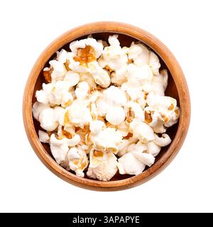 Popcorn, mais in un recipiente di legno. Semi di Zea mays varietà everta, espansi e gonfiati, dopo essere stati riscaldati. Snack, chiamati anche popcorn. Foto Stock