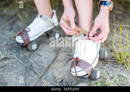 Una persona sta indossando pattini a rotelle con cinghie. La persona indossa un orologio. Concetto di divertimento e svago, mentre la persona si sta preparando per andare a rullo Foto Stock