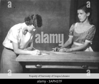Due studenti di recitazione al Berea College sono visti lavorare a un tavolo, forse preparandosi per una performance. Questa immagine mette in evidenza l'ambiente accademico e creativo del college. Foto Stock