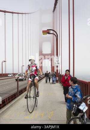 12 agosto 2011 - San Francisco, CA, Stati Uniti - Steve Meagher, Left, cavalca una penny farthing bicicletta attraverso il Golden Gate Bridge a San Francisco, California, sabato 13 agosto 2011. Meagher, di Orinda, California, ha guidato la bicicletta a ruote alte dal lago Tahoe a San Francisco per il suo 47esimo compleanno, e ha concluso il viaggio incontrando sua moglie all'Aquatic Park di San Francisco. (Immagine di credito: © John Green/Contra Costa Times/MCT/ZUMAPRESS.com) Foto Stock