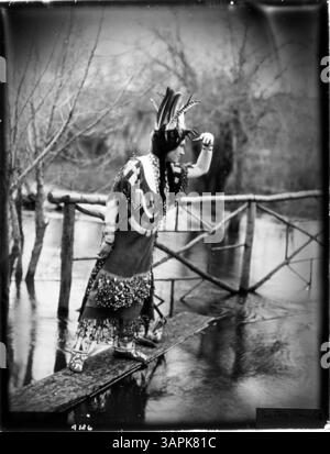 Una fotografia (PH036 4126) di Lee Moorhouse che mostra Esther Umahollis, una donna tribale Umpqua, in regalia con vari attrezzi. L'immagine mette in risalto il suo abbigliamento e gli strumenti culturali, riflettendo le tradizioni tribali Umpqua. Foto Stock