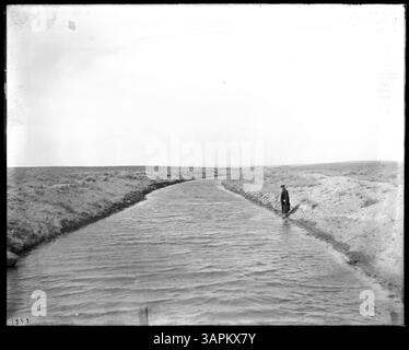 Fotografia di un uomo in piedi accanto al canale di irrigazione Hinkle, i canali e le porte d'acqua vicino a Pendleton. Foto Stock