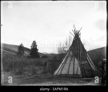 Fotografia che mostra i singoli campi indiani nella riserva indiana Umatilla. L'immagine cattura diversi campeggi distinti, fornendo informazioni sulle condizioni di vita della comunità. L'ambiente include tende e strutture tradizionali utilizzate dalle tribù dei nativi americani all'inizio del XX secolo. Foto Stock