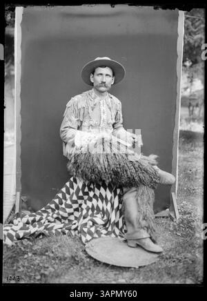 Munshang, un cowboy, viene fotografato in costume con un fucile in un ritratto a figura intera. La fotografia fa parte della collezione Lee Moorhouse Photographs della University of Oregon Libraries. Foto Stock
