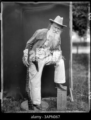 Fotografia di Joaquin Miller in costume di frontiera con un fucile, catturato da Lee Moorhouse. L'immagine a figura intera riflette la rappresentazione storica di Miller. Foto Stock